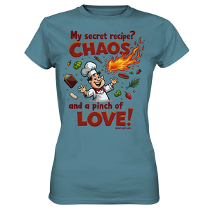 Ein cartoonhafter Koch mit weißem Kochhut und weiß-rotem Kochkittel, der fröhlich und mit ausgestreckten Armen lacht. Er steht inmitten eines Wirbels von Zutaten, darunter Flammen, Gemüse, Tomaten, und ein Kochbuch, die in der Luft herumfliegen. Der Koch Bright Lights Arts