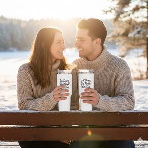 Weißer Thermobecher mit „Wir Eins“ Design in der Hand einer Frau, sonniger Stadtpark, emotionales Mockup