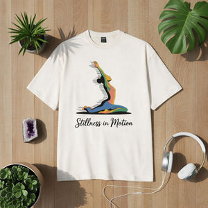 Beiges T-Shirt mit farbigem Yoga-Motiv einer fließenden Pose und Schriftzug „Stillness in Motion“, modernes Design für Yoga, Achtsamkeit und innere Balance – Bright Light Arts