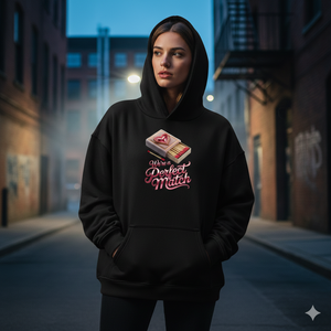 Person in gemütlichem Oversized Hoodie, Matchbox-Design, Kapuze sichtbar, warmes Gegenlicht, weiches Bokeh.