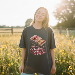 Lächelnde Frau im Perfect Match Oversized Shirt auf einer Blumenwiese bei warmem Sonnenuntergangslicht, emotionaler Vibe.