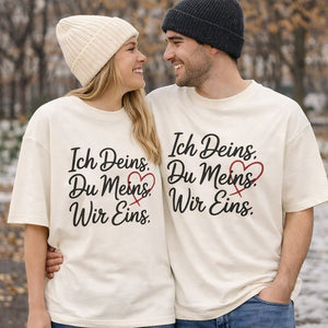 Verliebtes Paar trägt cremefarbene Oversized T-Shirts mit dem Liebes-Statement „Ich Deins. Du Meins. Wir Eins.“ – minimalistisches Bright Light Arts Paarshirt für Liebe, Verbundenheit und gemeinsame Momente
