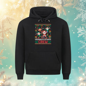 Schwarzer Ugly Christmas Sweater Hoodie „Weihnachtschaos Crew“ vor winterlichem Hintergrund – festlicher Oversized Hoodie von Bright Light Arts für Weihnachten.