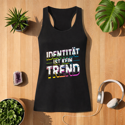 Schwarzes Damen Tanktop mit Aufdruck „Identität ist kein Trend“ im Bright Lights Arts Mockup auf Holzuntergrund mit Pflanzen, Kristall und Kopfhörern