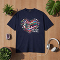 Blaues T-Shirt mit Herzmotiv aus internationalen Flaggen und Schriftzug „One Heart for All“, Symbol für Vielfalt, Zusammenhalt und globale Verbundenheit – Bright Light Arts