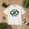 Bright Light Arts Premium T-Shirt „Focus on the Journey“ mit Unendlichkeits-Straßenmotiv als Lifestyle-Mockup auf hellem Hintergrund