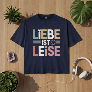 Navy Bright Light Arts T-Shirt mit dem Statement „Liebe ist leise“ in sanften Pastellfarben, Achtsamkeit und ruhige Liebe, präsentiert als hochwertiges Flatlay-Lifestyle-Mockup