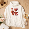 Off-White Premium Hoodie mit 3D-Ballon-Schriftzug „LOVE“ und Herzmotiv, kuscheliges Statement-Design in warmem Lifestyle-Setting – Bright Light Arts