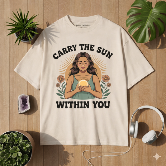 Beiges Oversized T-Shirt mit Carry the Sun Within You Design – spirituelles Mindfulness Motiv im Bright Lights Arts Mockup mit Pflanzen, Kristall und Kopfhörern auf Holz Hintergrund