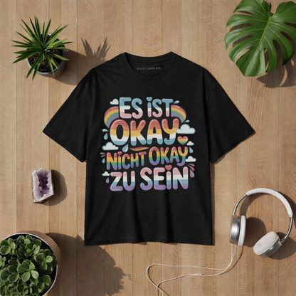 Beiges T-Shirt mit „Es ist okay nicht okay zu sein“ Design in bunten Regenbogenfarben – positives Mental Health Statement Shirt von Bright Lights Arts