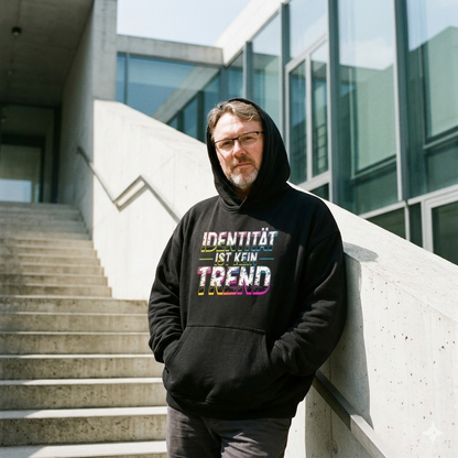 Person im schwarzen 380 GSM Heavy Cotton Oversized Hoodie mit dem Neon-Distressed-Schriftzug Identität ist kein Trend.