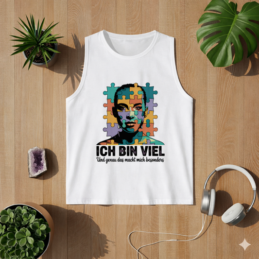Weißes Herren Tanktop mit „Ich bin viel“ Autismus Puzzle Portrait Design als Flatlay auf hellem Holzboden mit Pflanzen und Kopfhörern – modernes Lifestyle Mockup