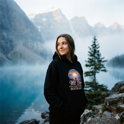 Frau im ultra-schweren schwarzen Bright Lights Arts Oversized Hoodie mit cineastischem Bergsee-Print.