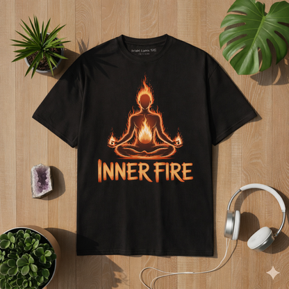 Black premium t-shirt with glowing inner fire meditation design, yoga silhouette with flames and “Inner Fire” text, displayed on wooden lifestyle mockup with plants and headphones, spiritual mindfulness apparel for meditation and yoga lovers