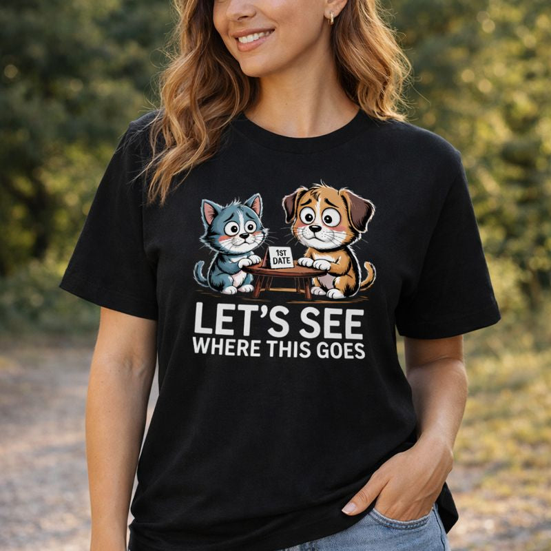 Schwarzes Damen Organic T-Shirt mit süßem Hund-und-Katze-Motiv beim ersten Date an einem kleinen Tisch mit Schild „1st Date“ und Schriftzug „Let’s see where this goes“, humorvolles Love-Design von Bright Light Arts.