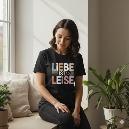 Schwarzes T-Shirt mit dem Schriftzug Liebe ist leise in harmonischen Naturtönen und kleinen Herzsymbolen von Bright Light Arts.