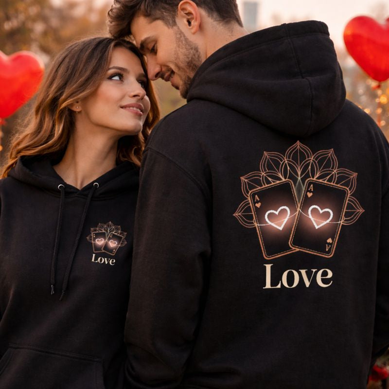 Verliebtes Paar trägt Bright Light Arts Oversized Hoodie mit „Love Luxury Heart“ Design – Frau mit kleinem Frontprint auf linker Brust, Mann mit großem Backprint, romantisches Valentinstagsmotiv bei natürlichem Licht