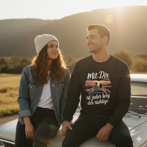 Paar beim Roadtrip im Sonnenuntergang, Mann trägt schwarzen Organic Sweatshirt mit Spruch, authentischer Lifestyle-Vibe