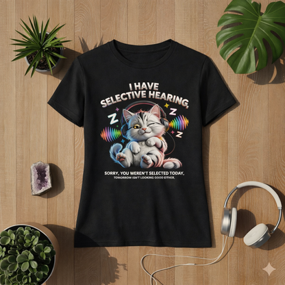 Schwarzes Premium Organic Damen T-Shirt mit lustigem Katzen Motiv „Selective Hearing“ – Katze mit Kopfhörern und bunten Soundwellen, taillierter Schnitt, flach liegendes Mockup auf Holz Hintergrund mit Pflanzen und Kopfhörern