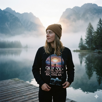 Frau im Sweatshirt mit „Mit Dir Welt am See“-Print blickt dankbar über nebligen Bergsee.
