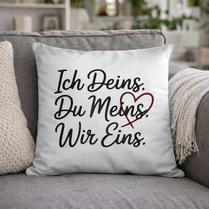 Weißes Premium-Kissen mit dem Liebes-Statement „Ich Deins. Du Meins. Wir Eins.“ auf einem Sofa im Wohnzimmer – minimalistisches Wohnaccessoire für Paare